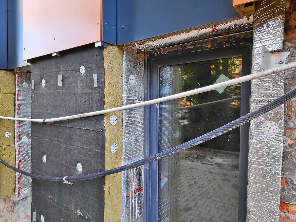 Panneaux de laine minérale haute densité fixés sur une paroi autour de la fenêtre